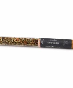 Imagen de Jardín Ayurveda en tubo de cristal con taza de infusión al fondo. Una presentación elegante, natural y perfecta como regalo wellness o detalle gourmet.